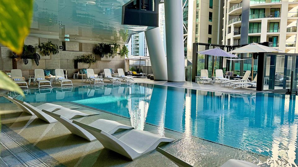 The pool is surrounded by lounges, cabanas and chairs.